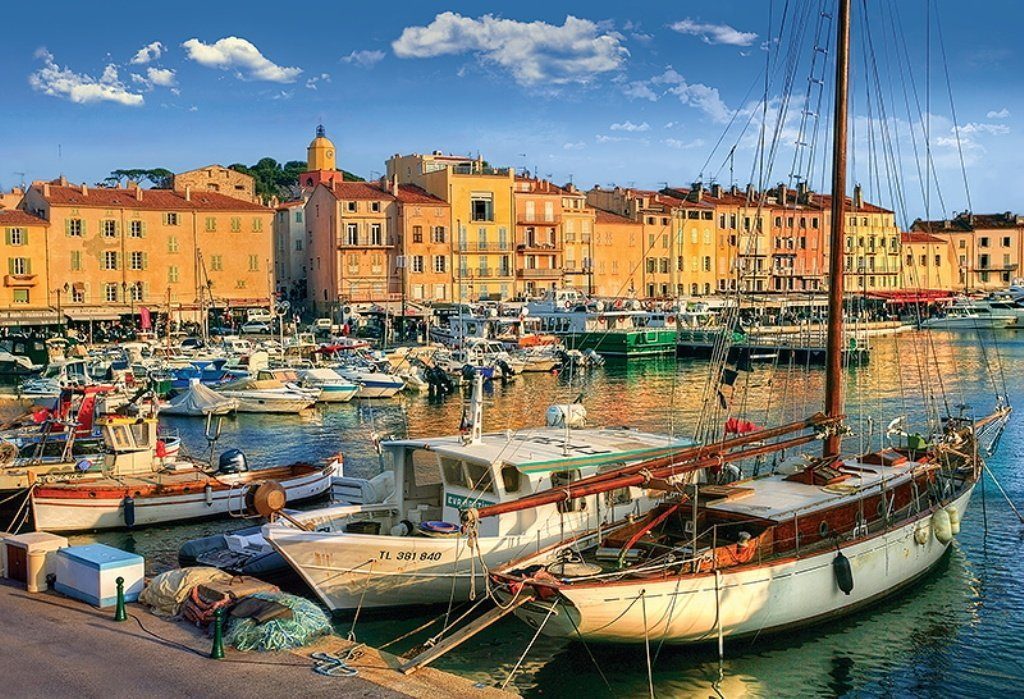 Photo du port de saint tropez au couché du soleil illuminant les bâtiments.