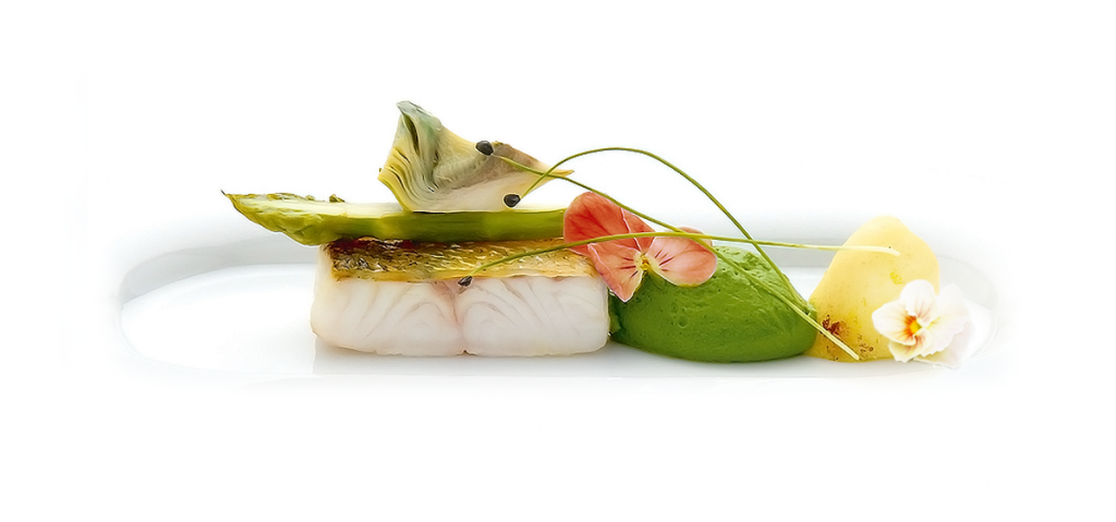 Filet de poisson cuit avec la peau, vue latérale, quenelle de crème verte, fleur blanche et coeur d'artichaut.